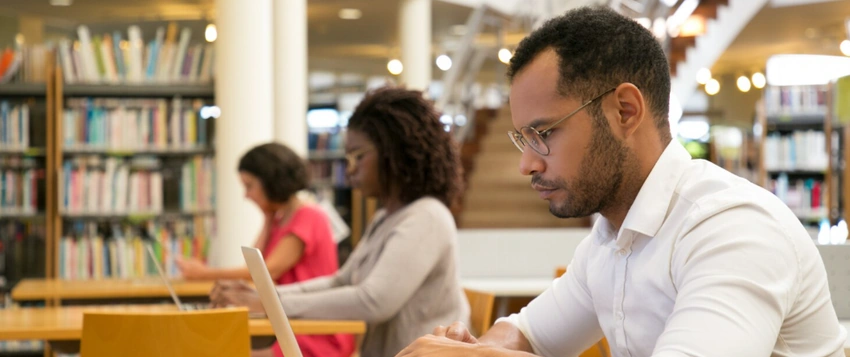 Higher Certificate in Business Management student studying in a library