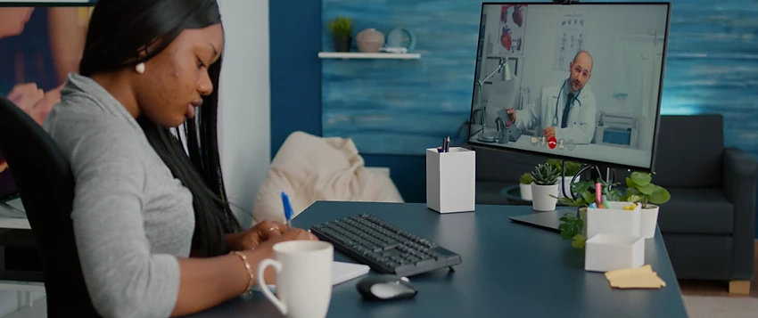 Patient taking notes during an online telehealth consultation with a doctor