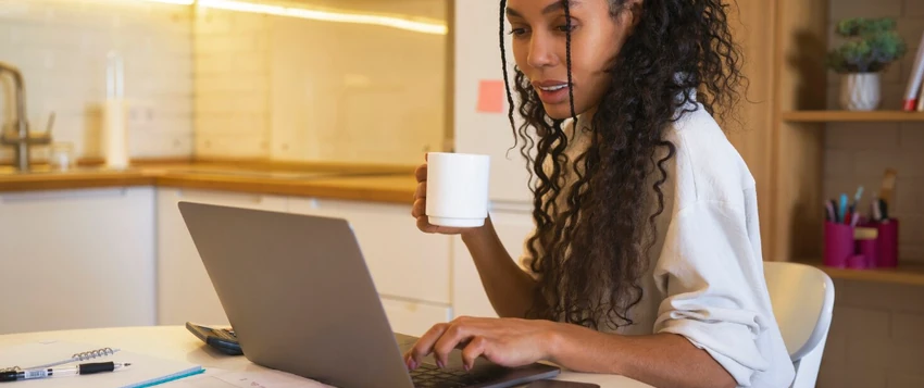 Woman studying business management online using a laptop and business documents