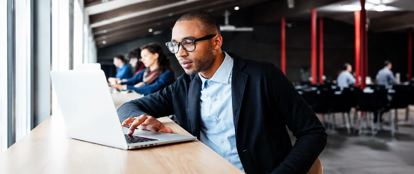 Business professional preparing an MBA application on a laptop