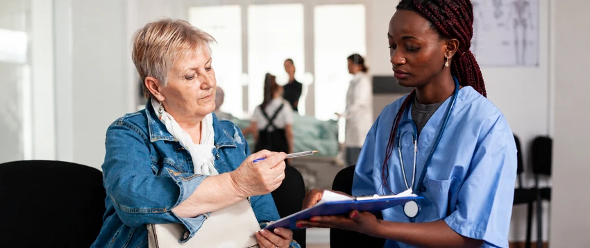 Nurse discussing patient information with an older patient in a healthcare setting