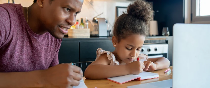 Parent supporting a child during online school learning at home