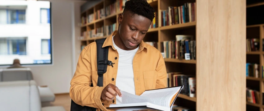 Postgraduate student researching qualification options in a university library in South Africa.