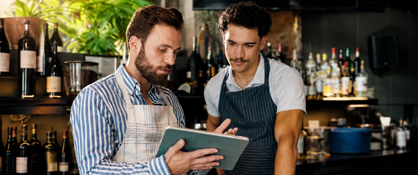 Retail professionals reviewing business information on a tablet in a customer-facing environment