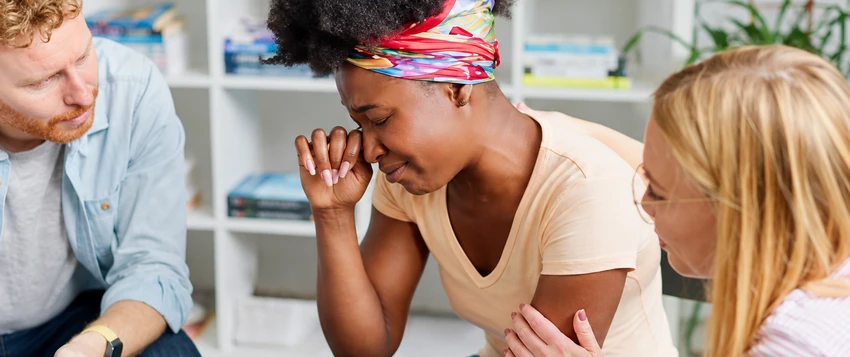 Colleagues supporting an employee experiencing emotional distress in a workplace setting