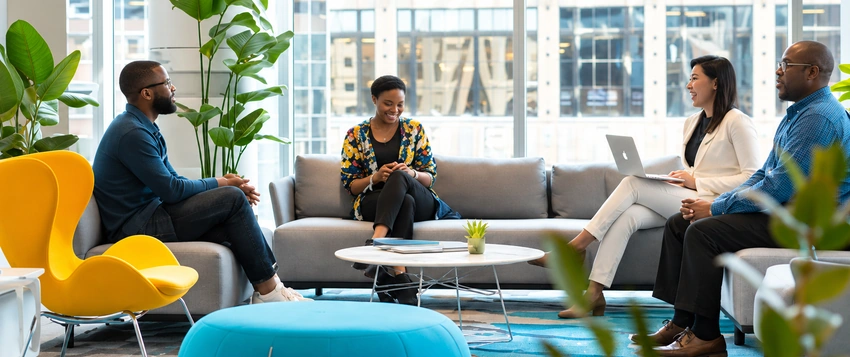 Diverse professionals discussing workplace behaviour and organisational dynamics in a modern office setting